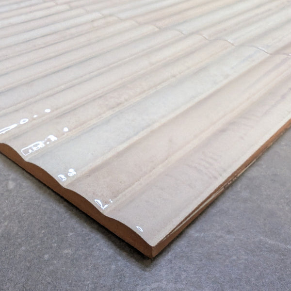 Angled close-up of ivory vertical reeded tile showing curved ridges