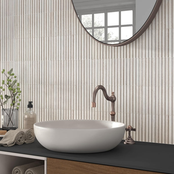 Modern bathroom wall featuring ivory reeded ceramic tile behind basin