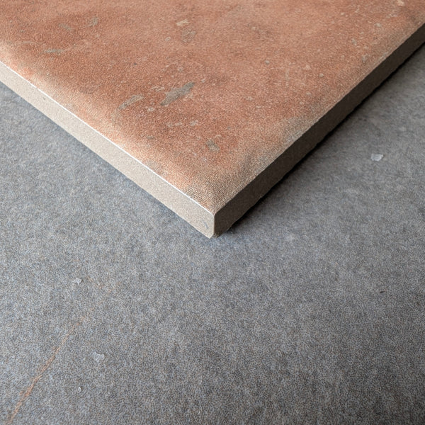 Close-up of textured terracotta tile with natural speckling and matte finish